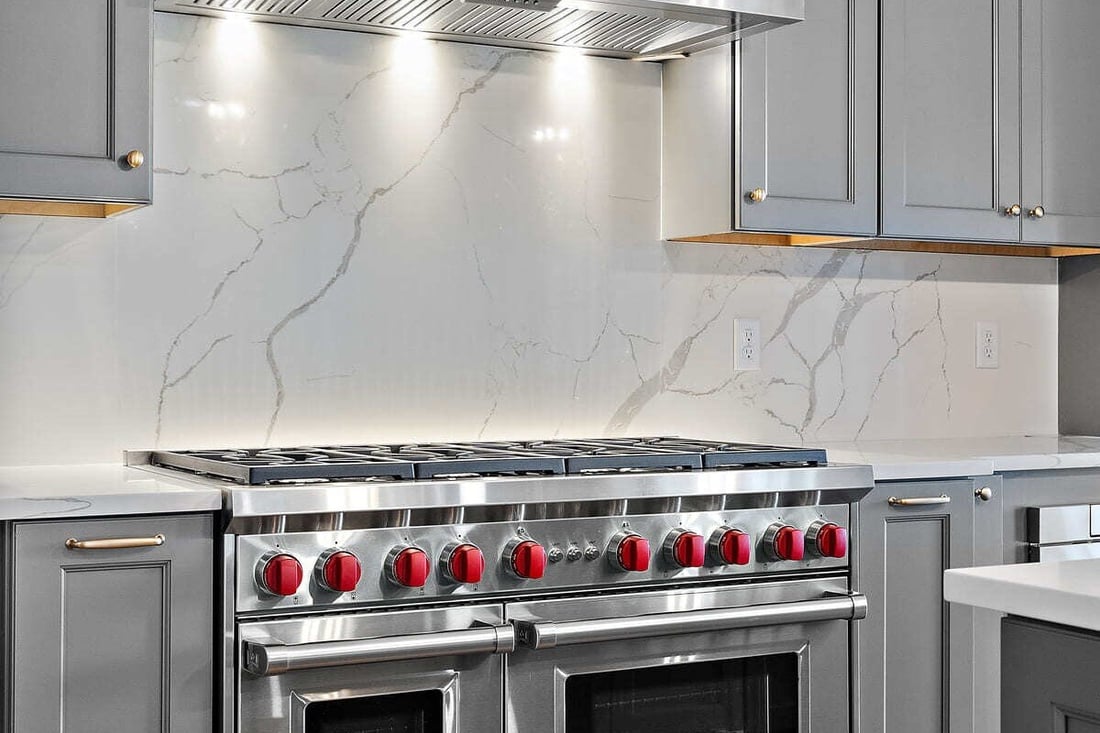 High-end oven range in front of slab backsplash in Delaware custom home by Bromwell Construction