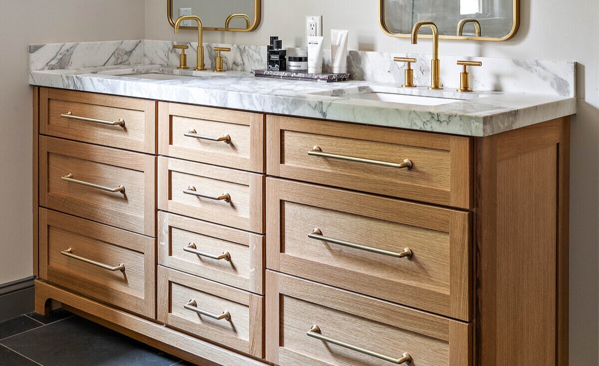 Double vanity with brass fixtures in Delaware bathroom remodel by Bromwell Construction