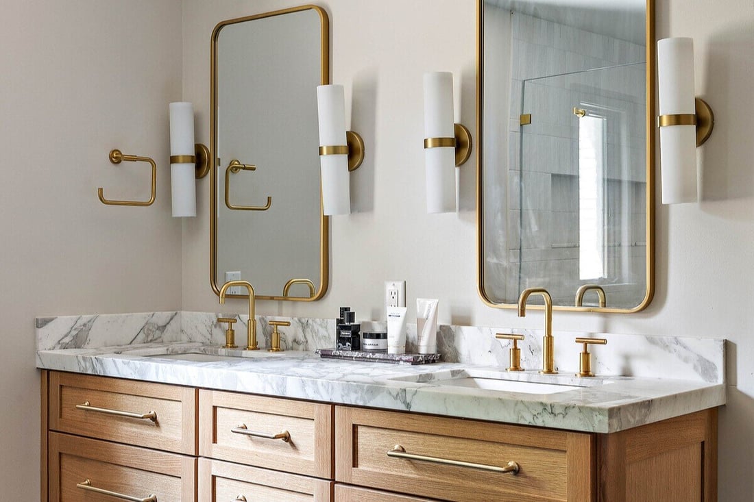 Double vanity with brass fixtures in bathroom remodel by Bromwell Construction