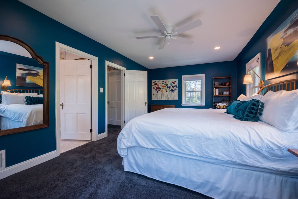 Bedroom with blue painted walls and carpet in Delaware pool house addition by Bromwell Construction