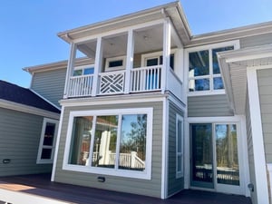 Exterior of home with second story covered porch with white posts