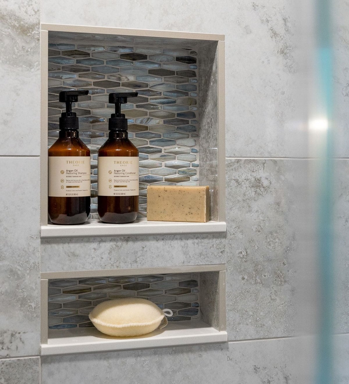 Built-in shower niche with mosaic tiling and soap holder in bathroom remodel by Bromwell Construction