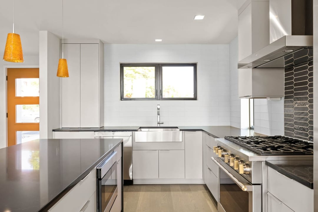 Contemporary kitchen remodel by Bromwell Construction with white flat panel cabinetry