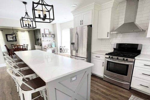 Delaware area kitchen with white cabinets, stainless appliances, large island, and pendant lights-1
