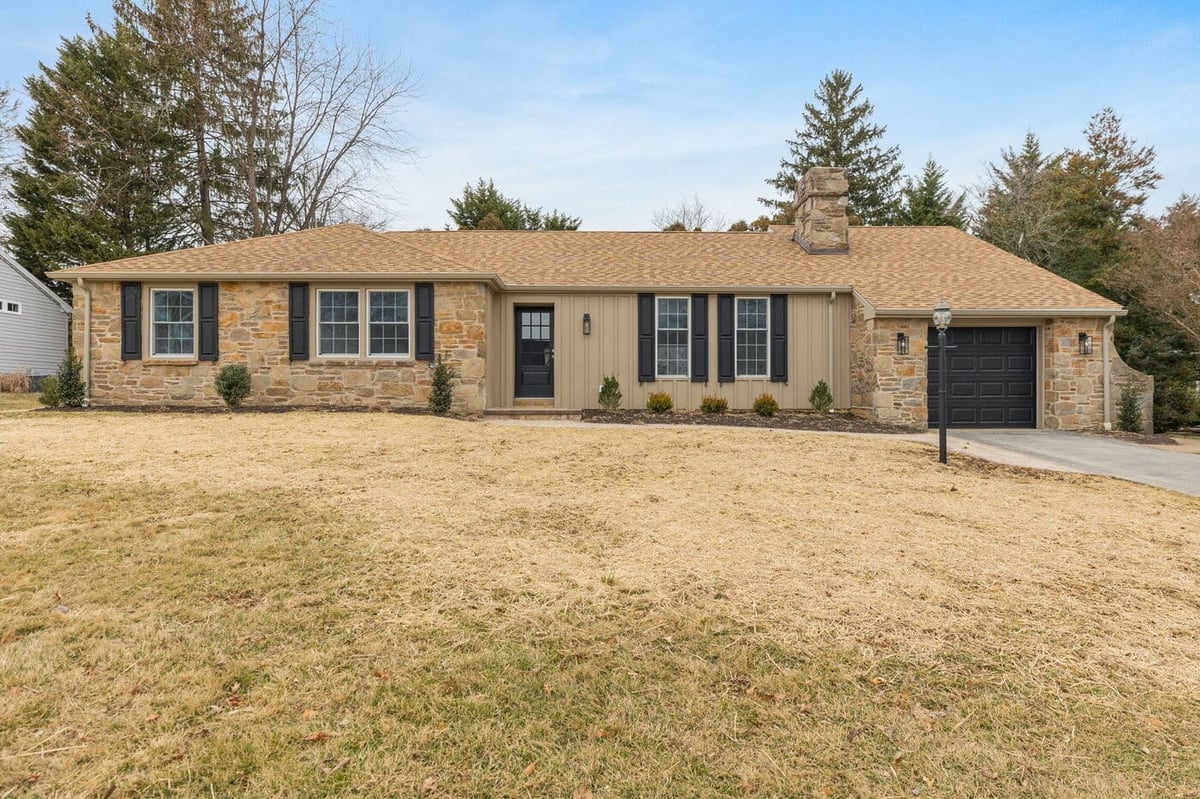 Delaware one-story home front exterior with black window shutters and garage door 