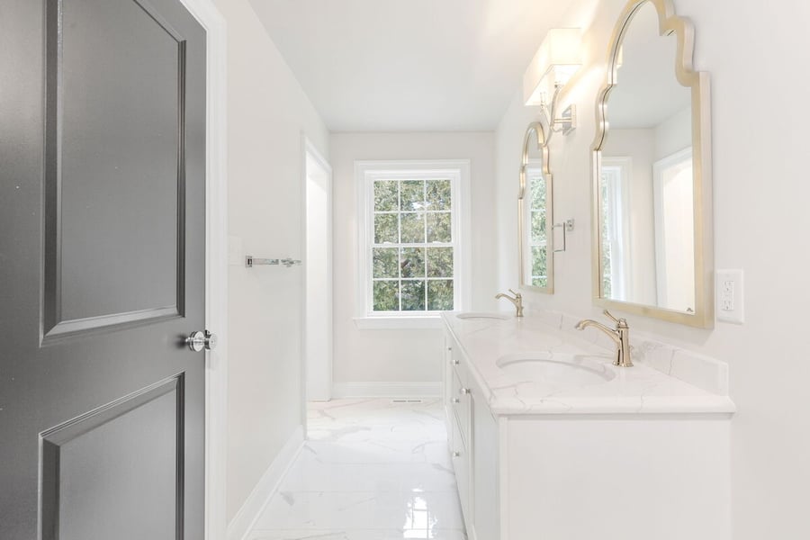 Door opening to luxury bathroom addition in Delaware home with double vanity
