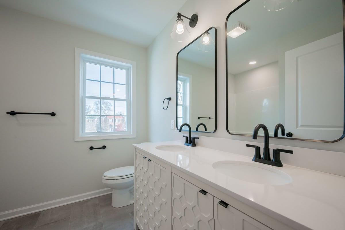 Double bathroom vanity with black faucet fixtures in Delaware custom home 