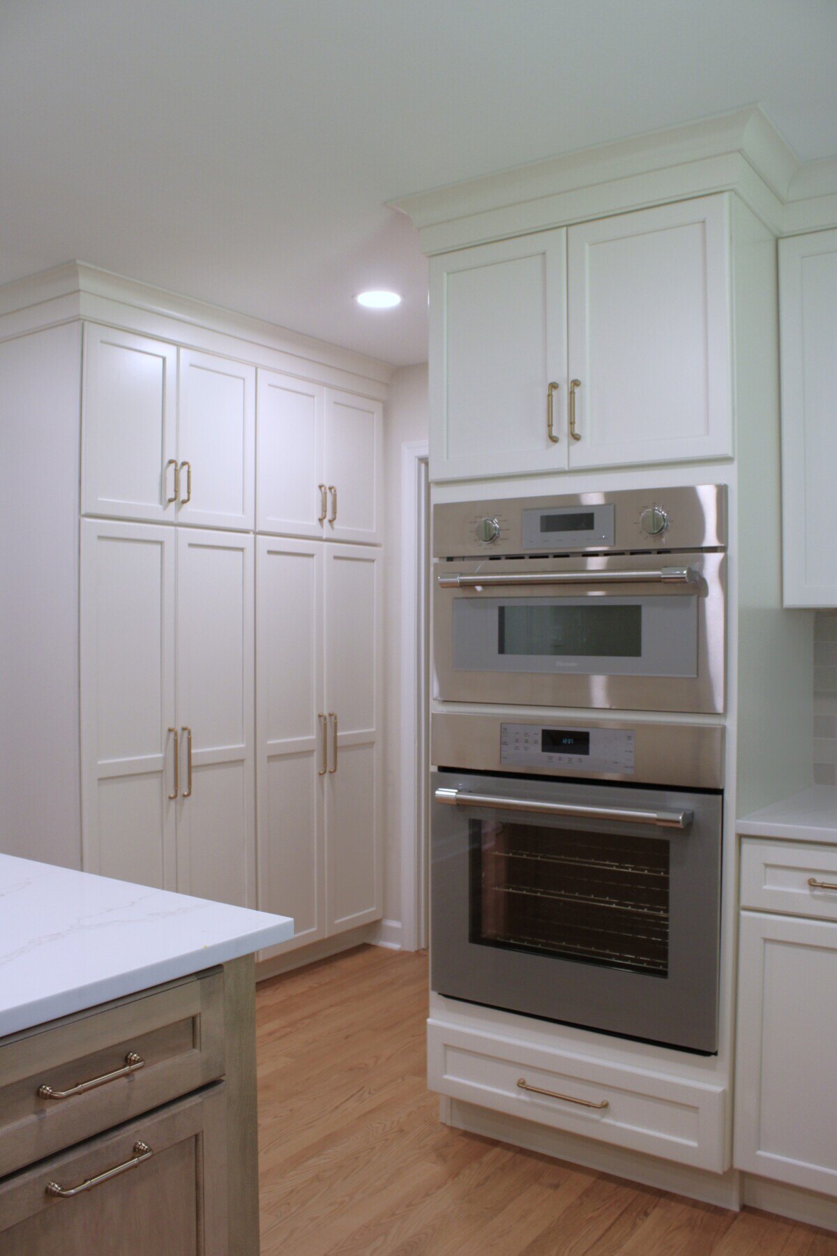 Double oven in white kitchen with floor-to-ceiling cabinetry by Bromwell Construction