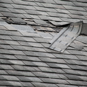 Missing and curling shingles in need of replacement on a roof in Delaware