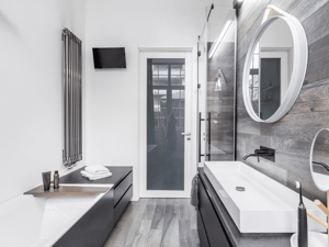 Sleek modern bathroom remodel with gray wood walls and flooring. Trough-style sink