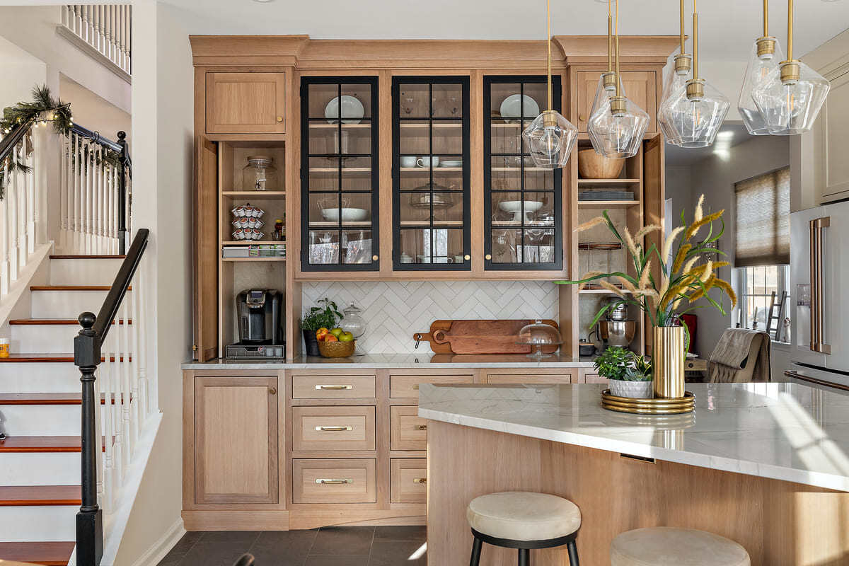 Island and cabinetry with glass-front panels in Delaware home remodel by Bromwell Construction