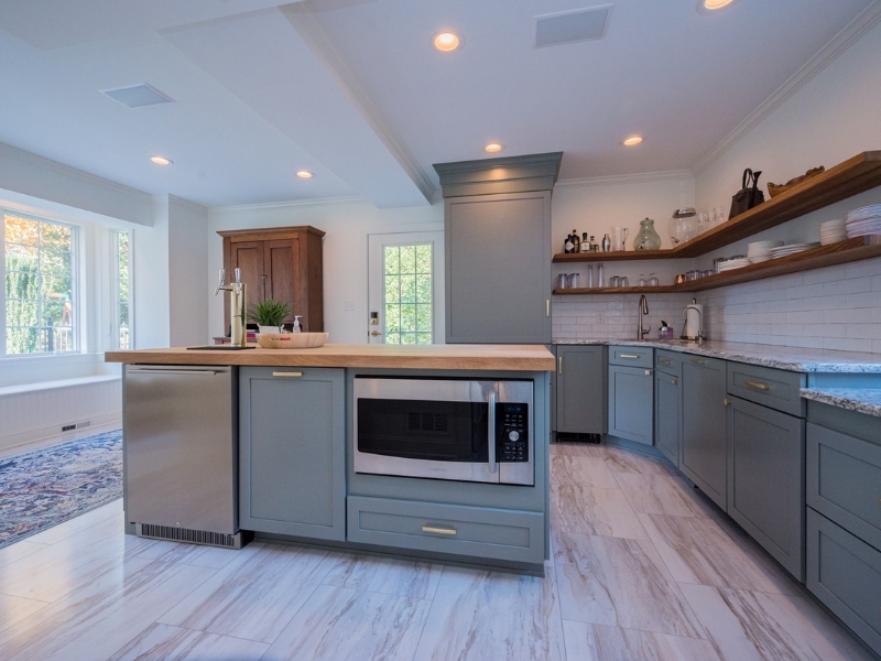Island with built-in microwave and dishwasher in Delaware kitchen remodel with open shelving