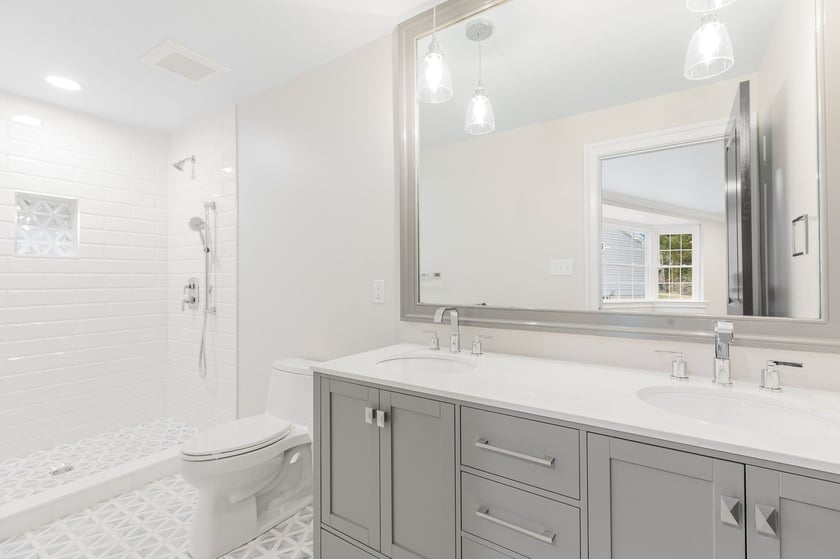 Luxury bathroom remodel in Delaware with gray double vanity and walk-in shower with white subway tile