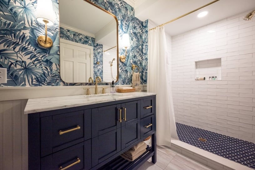 Luxury blue bathroom remodel in Wilmington, DE with brass fixtures and walk-in shower with inset shelving-1