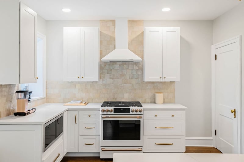 Luxury white kitchen remodel in Wilmington, DE with brass fixtures and recessed lighting