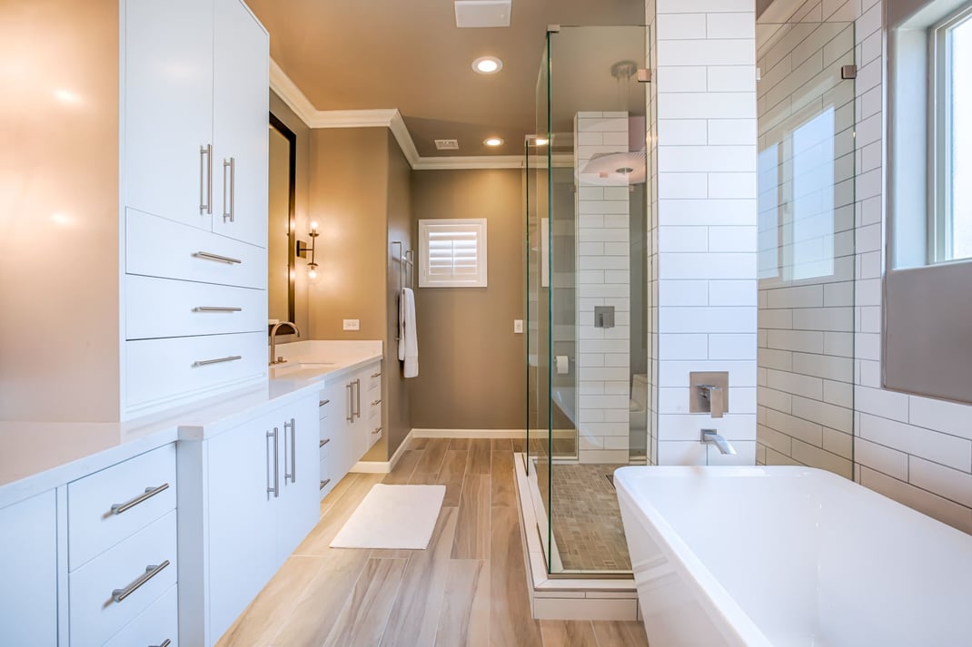 Modern Delaware bathroom with white vanity, glass shower, soaking tub, and tile flooring