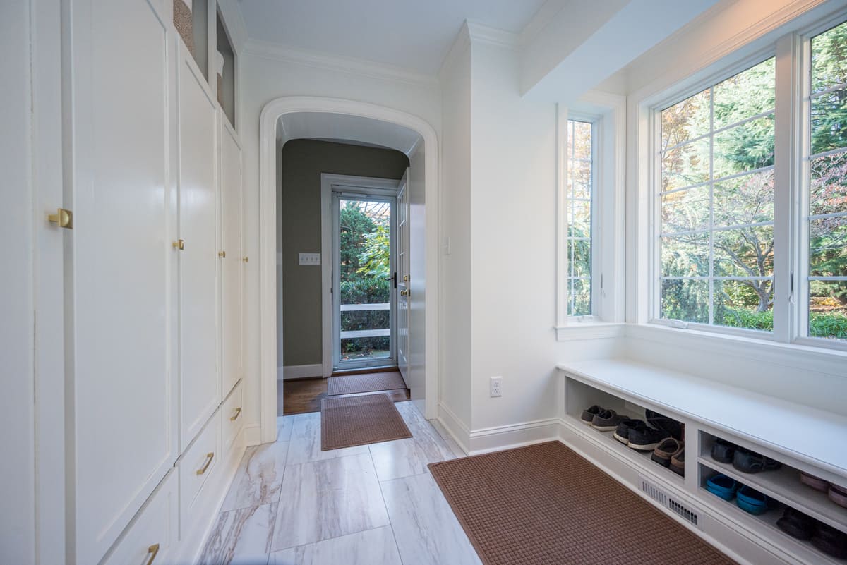 Mudroom with built-in shoe storage and floor-to-ceiling storage in custom pool house by Bromwell Construction