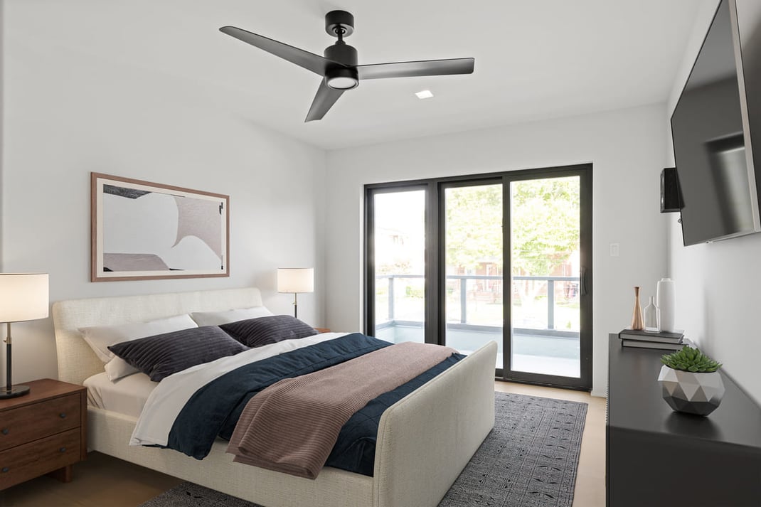 Primary bedroom in Delaware custom home with glass doors to balcony