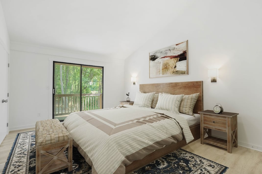 Primary bedroom with sliding door to balcony in Delaware home remodel