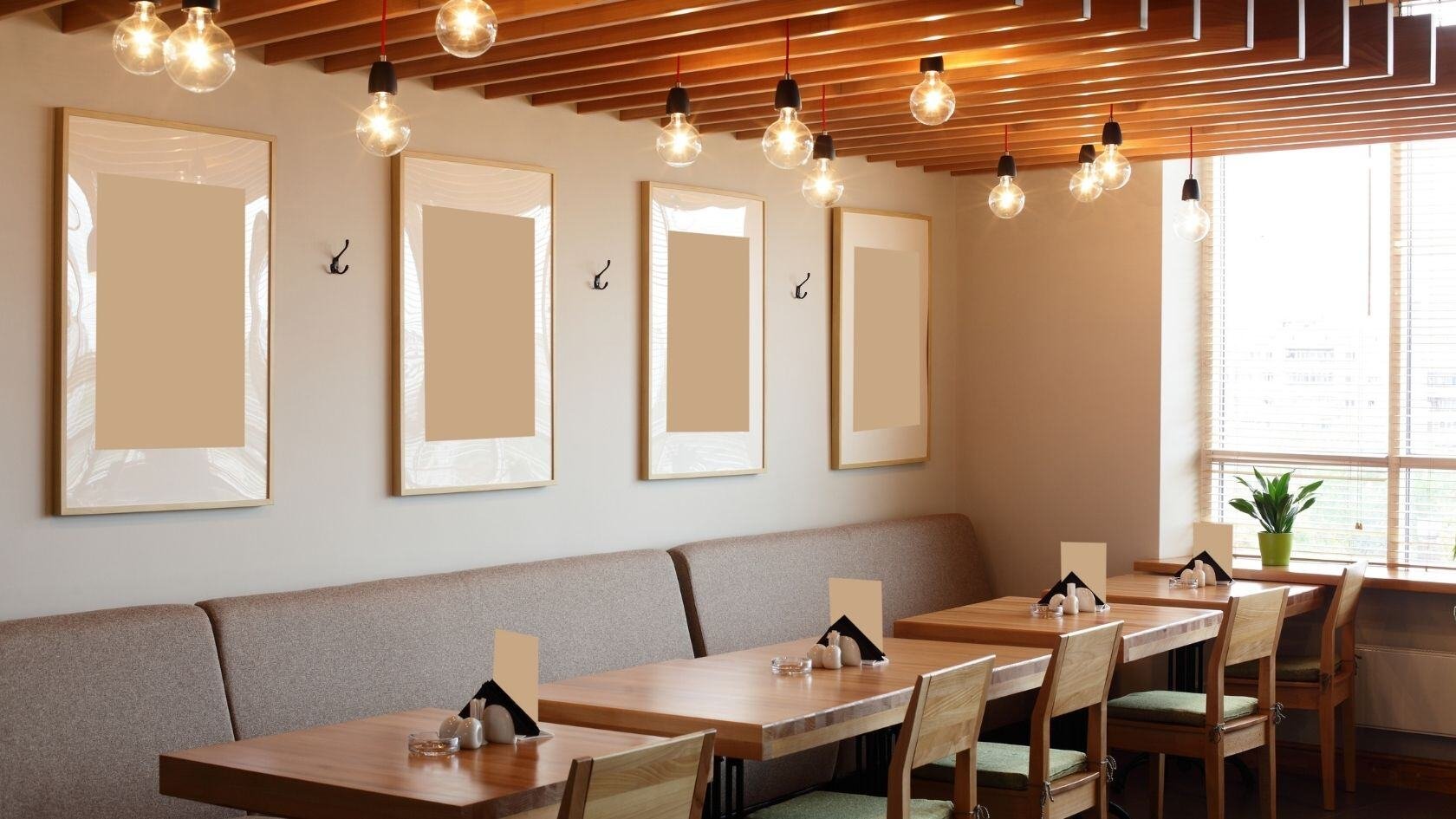 Restaurant interior with tables and chairs beneath pendant lighting