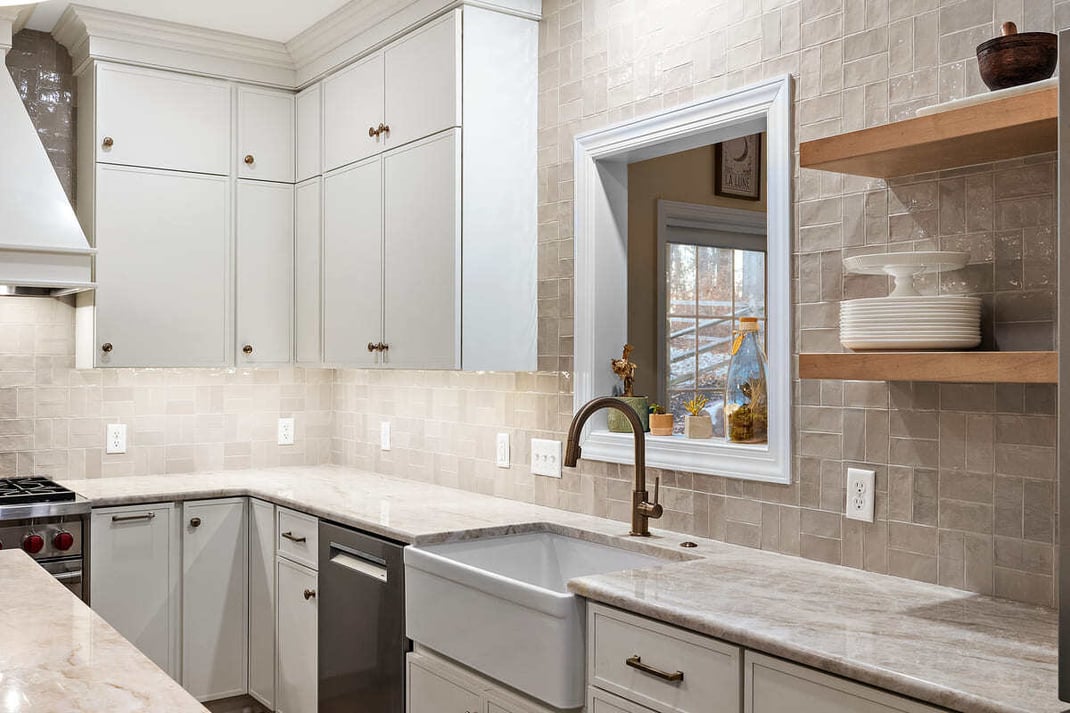 Kitchen remodel with farmhouse-style sink and white cabinets by Bromwell Construction