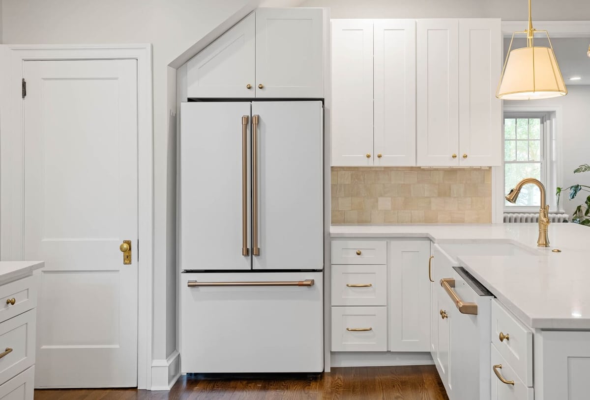 White luxury kitchen remodel in Delaware with brass fixtures on shaker cabinets