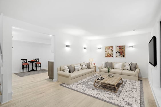 basement living space addition with new flooring and sconce lighting