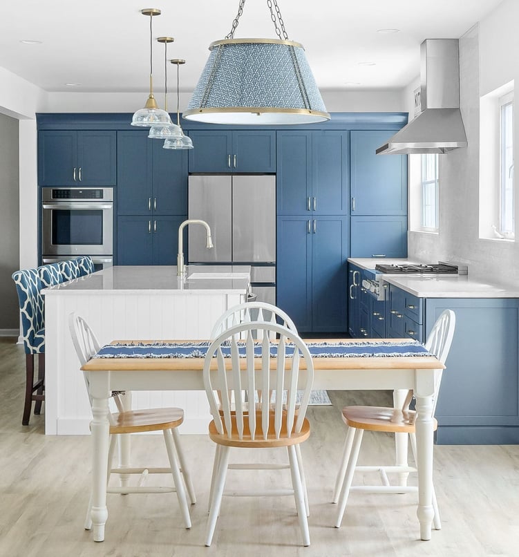 dining table in front of luxury blue kitchen with white island