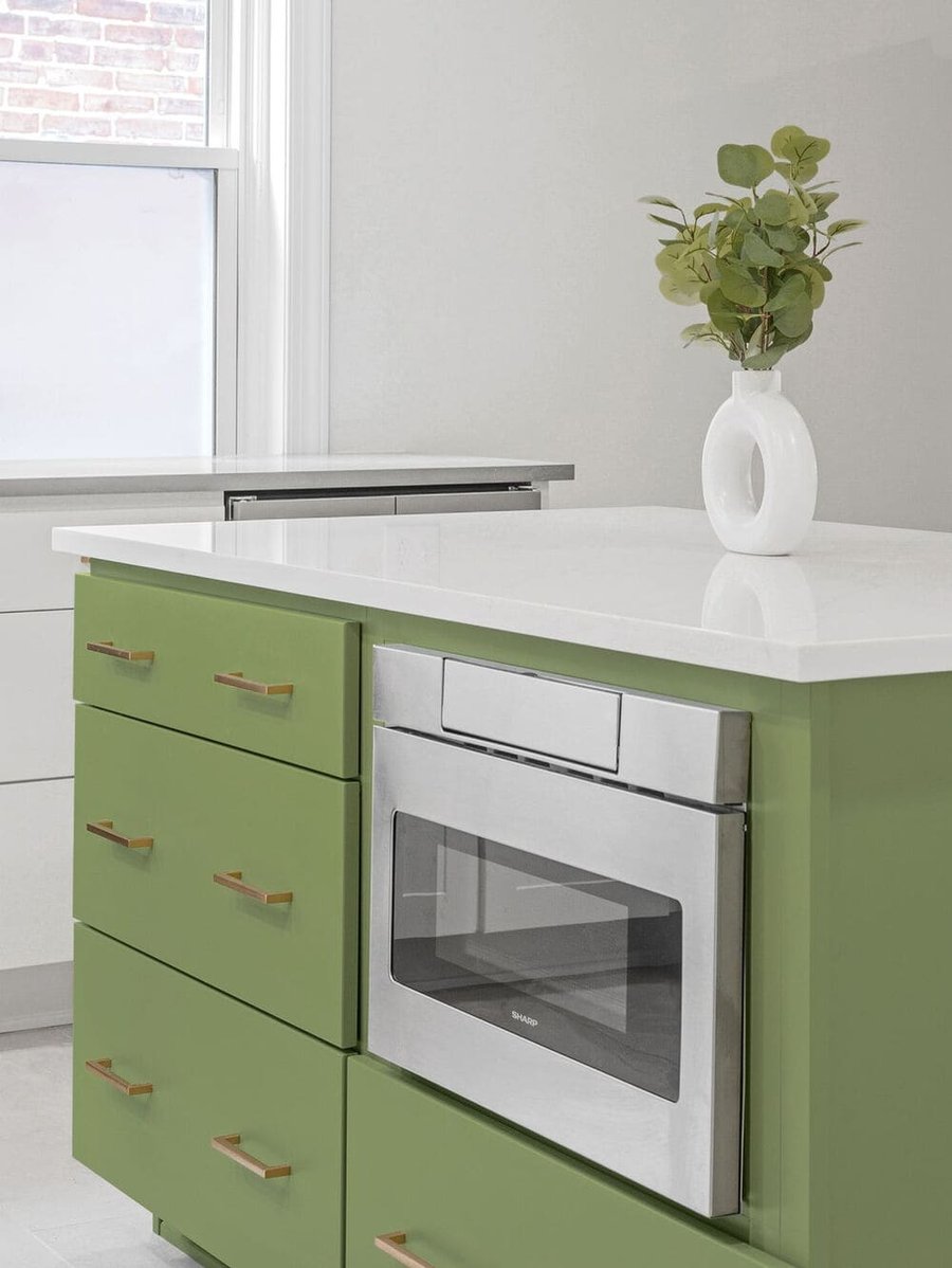 kitchen island with green storage drawers and white countertop