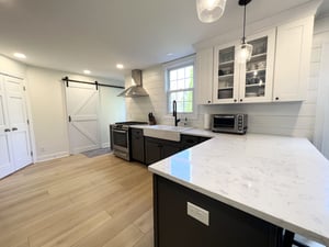 Modern kitchen remodel with white sliding farmhouse door and black cabinetry