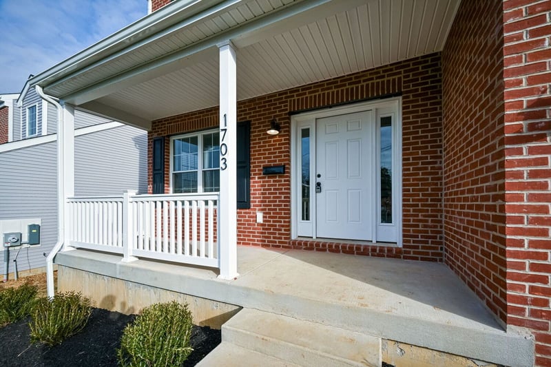 porch front exterior addition on brick home with white posts